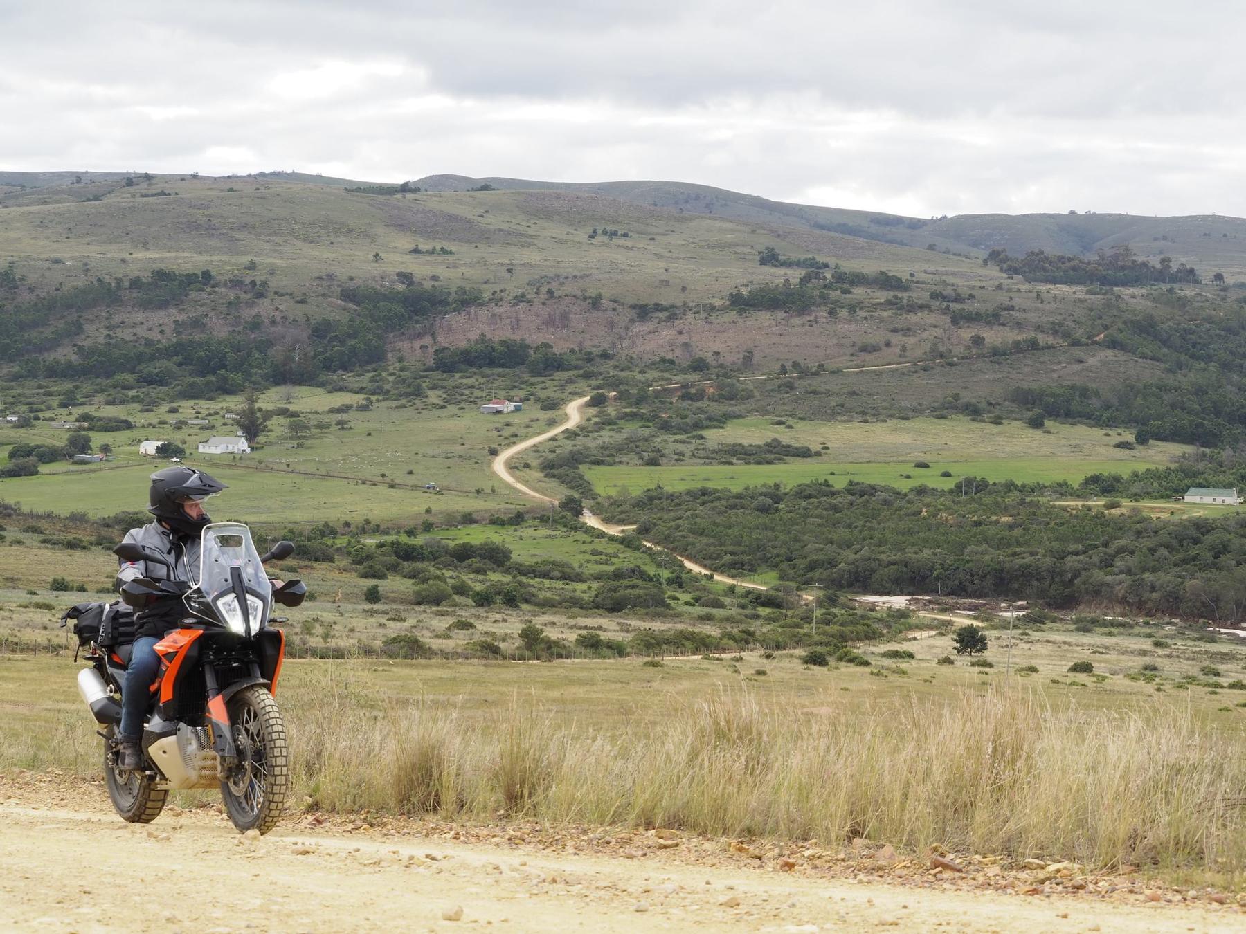 Rider's-eye view from the cockpit of a KTM 790 Adventure, GPS route loaded, overlooking an Eastern Cape valley and gravel road